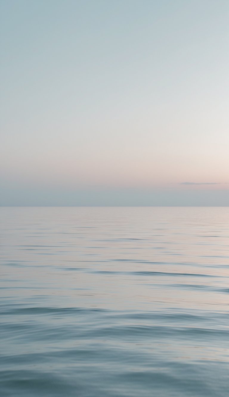 A calm ocean horizon with soft colors and a hazy sky, showing peaceful water and an empty horizon.
